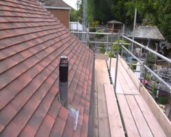 New brown clay tile roof being re-laid with timber battens on a Gloucestershire home