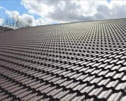 Expanse of new brown roof tiles against a clear sky after a Gloucestershire re-roof