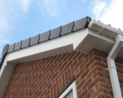 White soffit and fascia at a brick gable corner in Gloucestershire