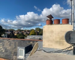 Flat roof and chimney with pots overlooking a Gloucestershire town