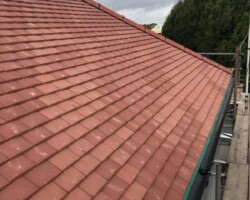 Close-up of repaired red roof tiles with scaffold access in Gloucestershire