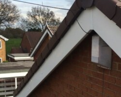 White bargeboard and fascia on a brick gable apex in Gloucestershire