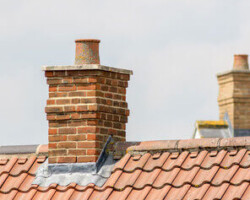 Repaired brick chimney stack on a tiled roof in Gloucestershire