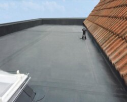 Large grey flat roof next to a pitched tiled roof in Gloucestershire