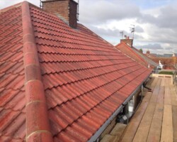 Fresh red tile roof ridge after a roof replacement on a Gloucestershire home