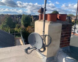 Rendered chimney stack with pots overlooking rooftops in Gloucestershire