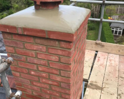 Brick chimney stack with a new concrete cap during repairs in Gloucestershire