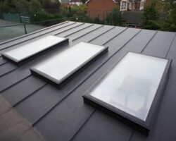 Modern dark tiled roof with three rooflights after a full re-roof in Gloucestershire